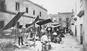 "Mexico City street market 1885". Licensed under Public domain via Wikimedia Commons.