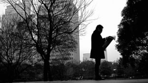 reading newspaper in park